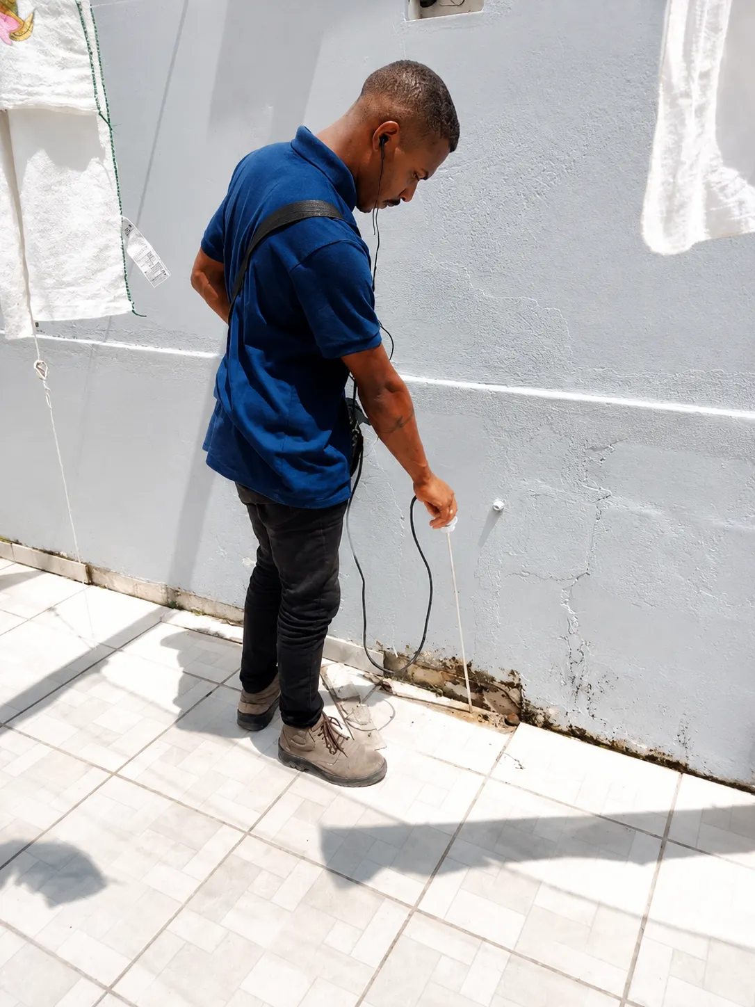 Profissional realizando detecção precisa de vazamento em parede externa